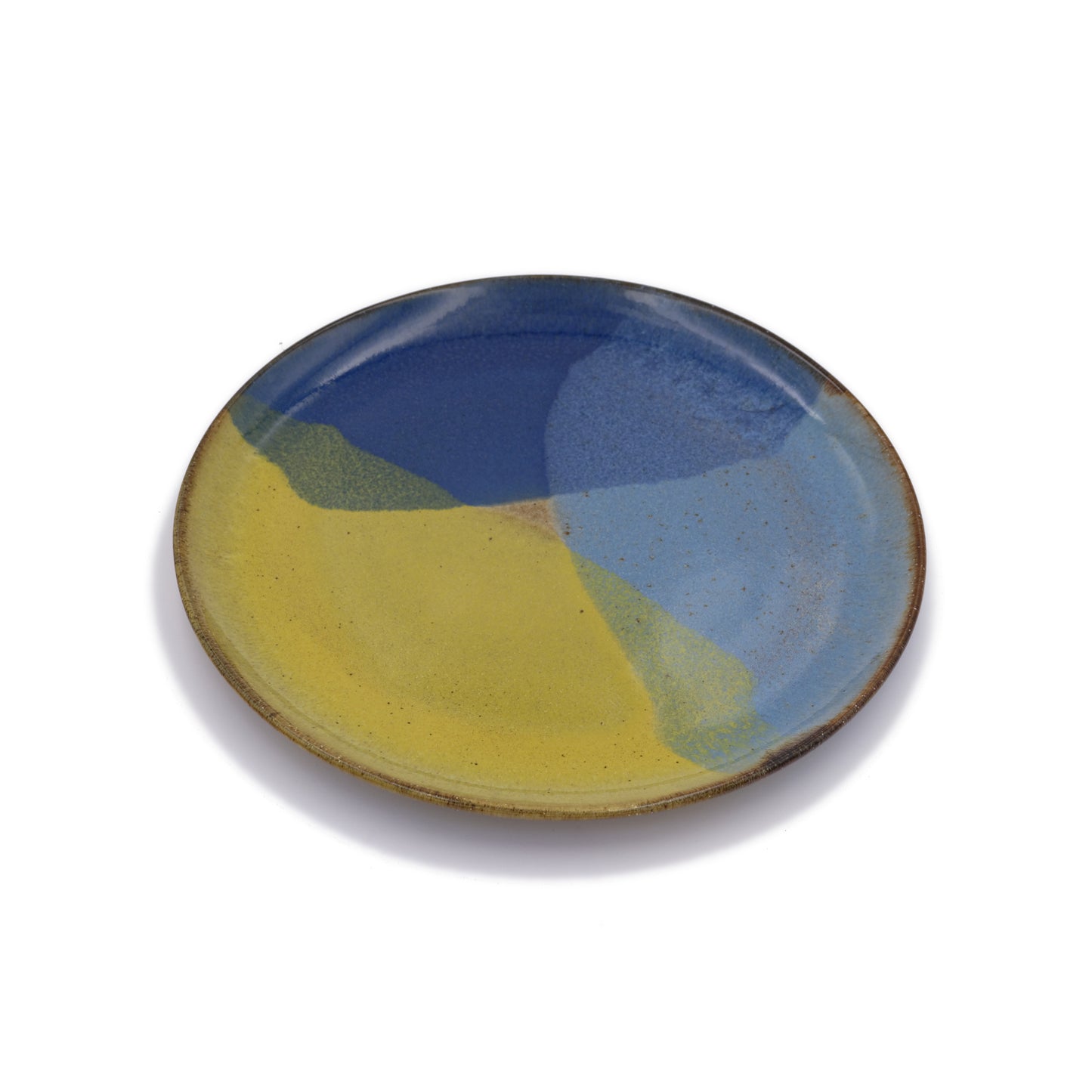 vue de biais, assiette plate en grès naturel avec motif tricolore bleu profond, bleu ciel et jaune