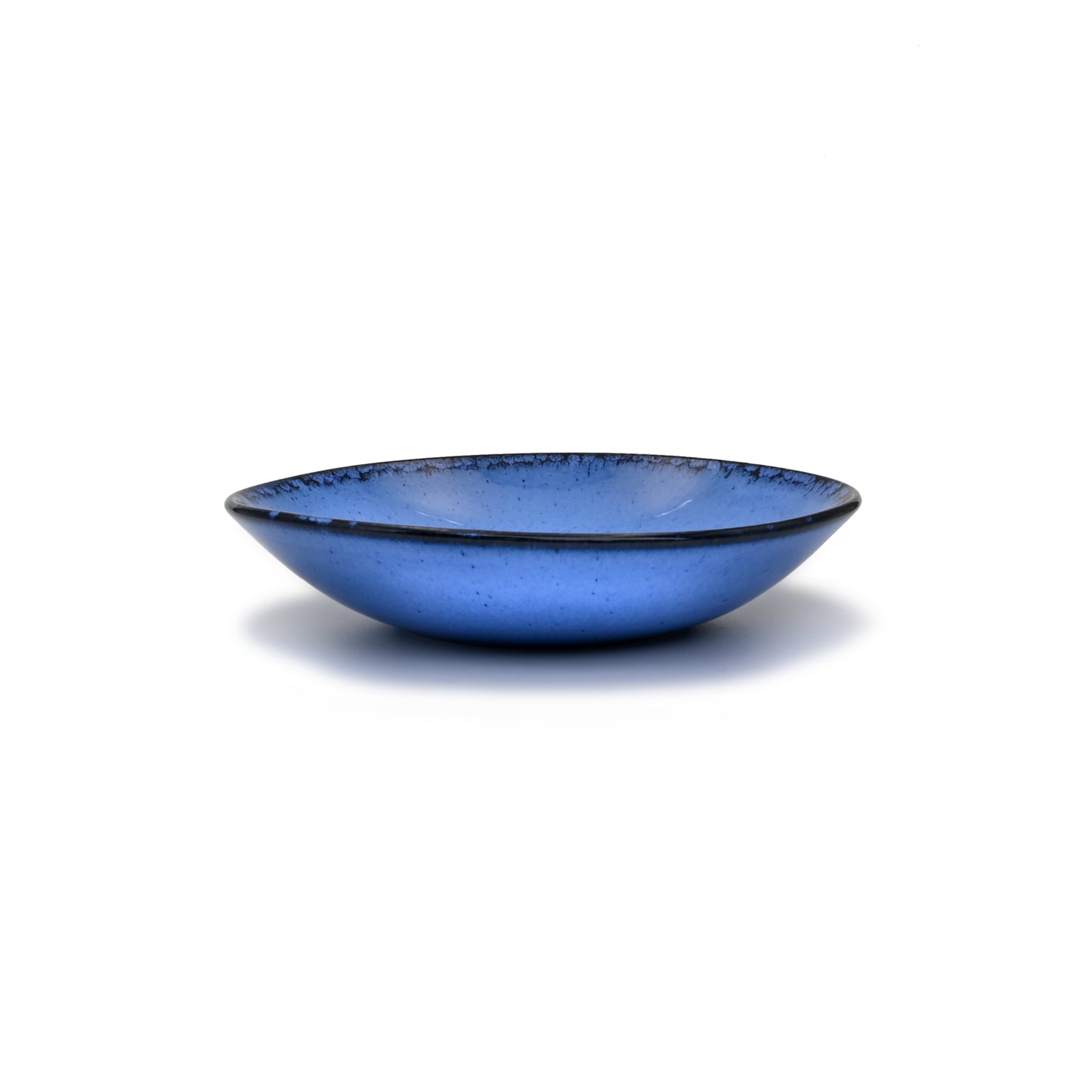 vue de profil, assiette creuse en grès naturel et émail réactif bleu profond
