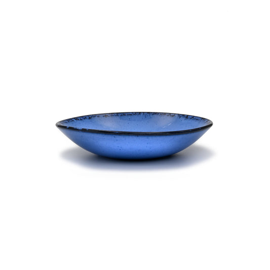 vue de profil, assiette creuse en grès naturel et émail réactif bleu profond